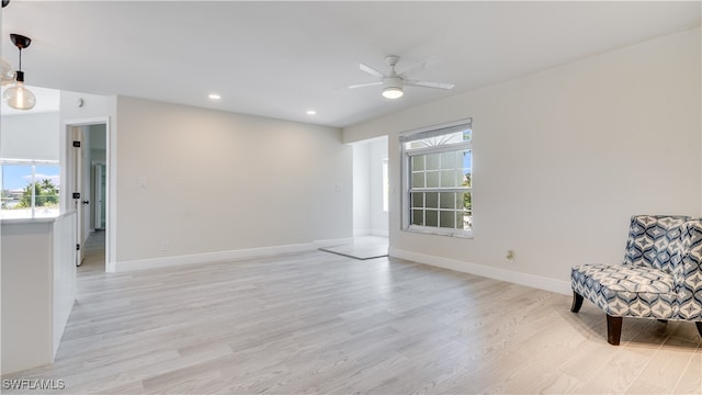 unfurnished room featuring ceiling fan, plenty of natural light, and light wood-type flooring