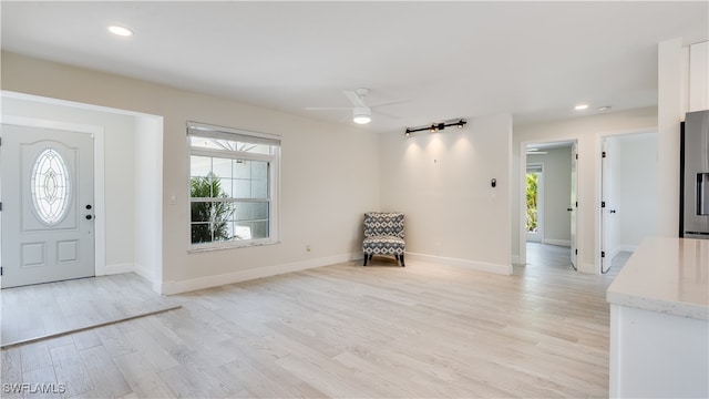 foyer entrance with light wood-type flooring, ceiling fan, and plenty of natural light