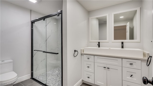 bathroom featuring tile patterned flooring, vanity, toilet, and a shower with shower door