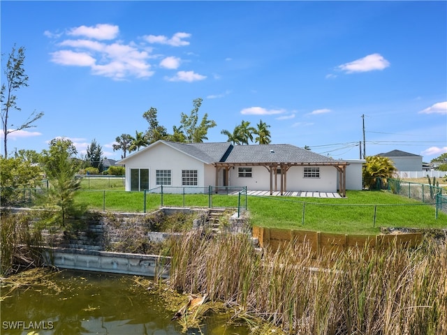 rear view of property with a water view and a lawn