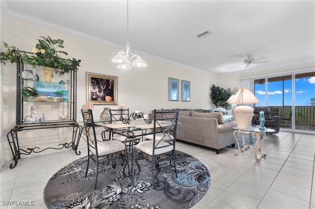 dining area featuring light tile patterned floors, ornamental molding, and ceiling fan with notable chandelier