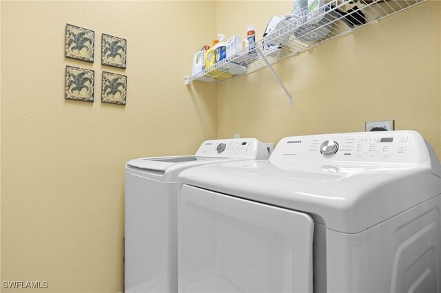 clothes washing area with washing machine and clothes dryer