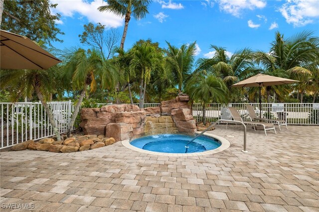 view of swimming pool featuring a patio and a hot tub