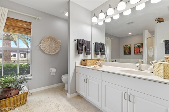 bathroom featuring tile patterned flooring, vanity, a shower with door, and toilet