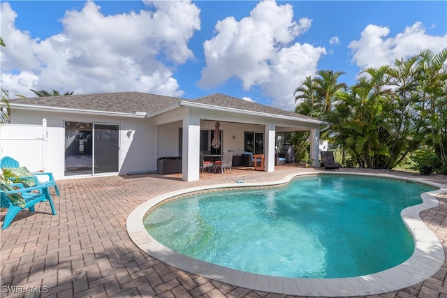 view of pool featuring a jacuzzi and a patio area