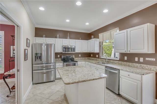 kitchen featuring ornamental molding, stainless steel appliances, sink, white cabinets, and a center island