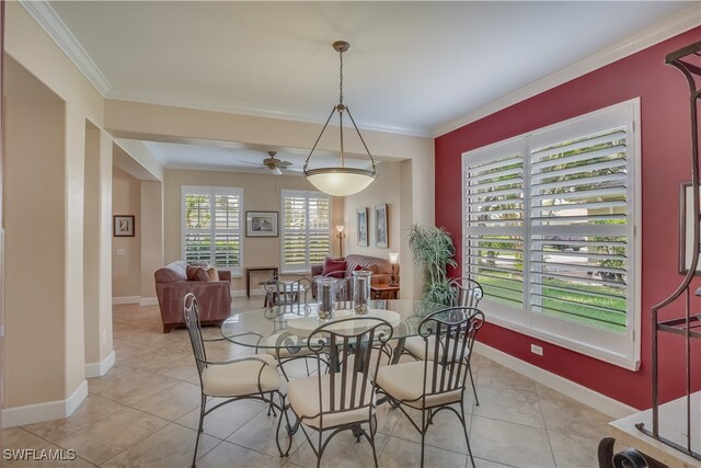 dining space with ceiling fan, crown molding, and light tile patterned flooring