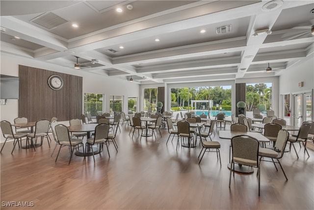 dining room with beam ceiling, ceiling fan, wood-type flooring, and coffered ceiling