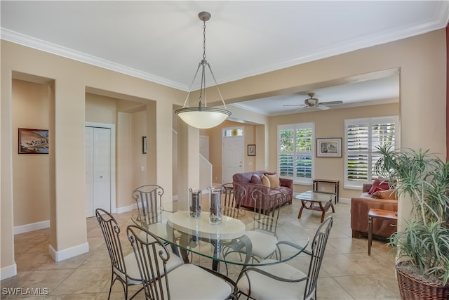 tiled dining area featuring ceiling fan and crown molding