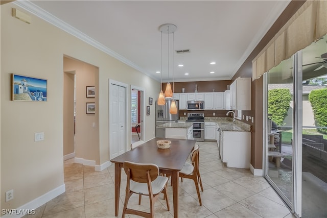 kitchen featuring pendant lighting, sink, ornamental molding, a kitchen island, and stainless steel appliances