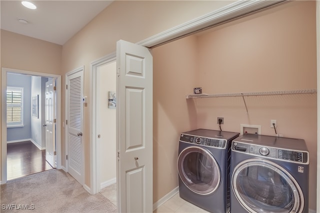 laundry area featuring washing machine and clothes dryer and light carpet