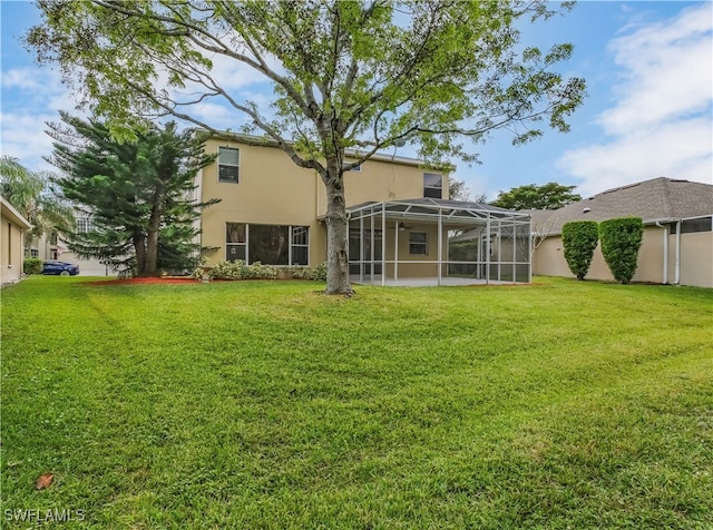 rear view of house featuring a lanai and a yard