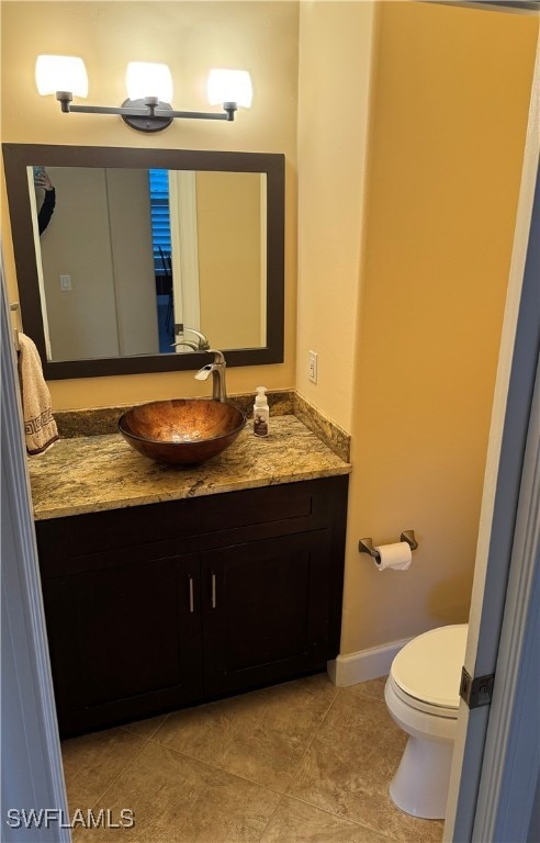 bathroom featuring tile patterned flooring, vanity, and toilet