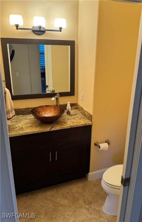 22890 Forest Ridge Dr, Estero, FL 33928 - bathroom featuring vanity, toilet, baseboards, and tile patterned floors