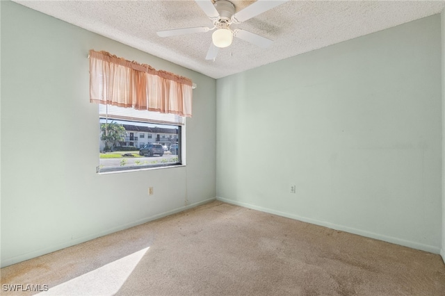 carpeted spare room with ceiling fan and a textured ceiling