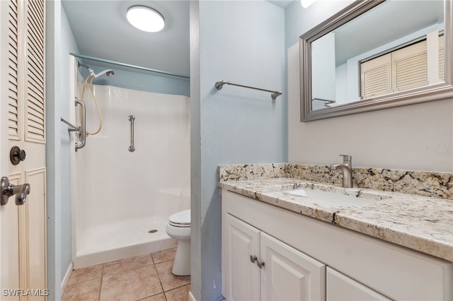 bathroom with a shower, vanity, toilet, and tile patterned flooring