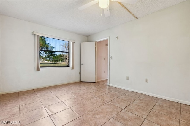 tiled spare room featuring a textured ceiling and ceiling fan