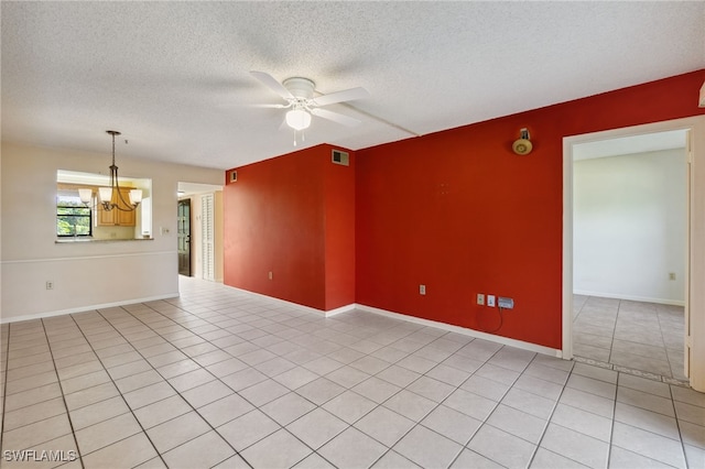 tiled spare room with ceiling fan with notable chandelier and a textured ceiling