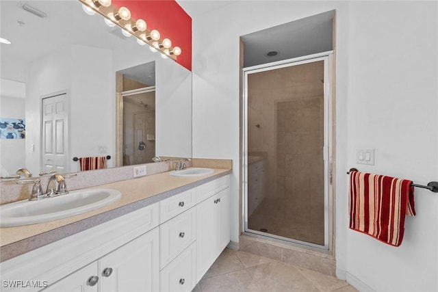 bathroom with tile patterned flooring, a sink, a stall shower, and double vanity
