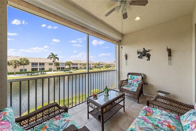 sunroom / solarium with a ceiling fan, a water view, and a residential view