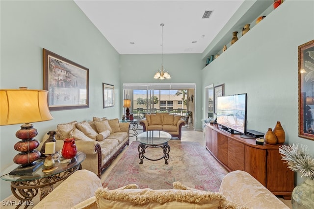 living room featuring light tile patterned floors, a high ceiling, and an inviting chandelier