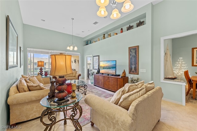 tiled living room featuring a towering ceiling and a chandelier