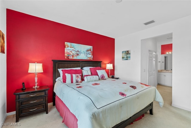 carpeted bedroom featuring ensuite bathroom