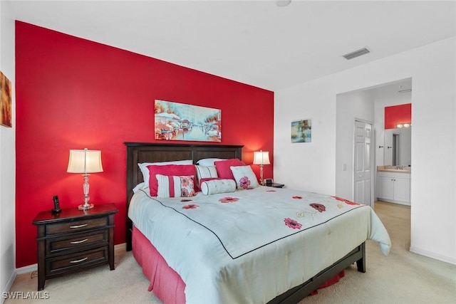bedroom featuring carpet floors, ensuite bathroom, baseboards, and visible vents