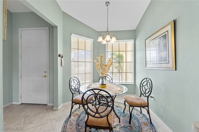 tiled dining room with a notable chandelier and lofted ceiling