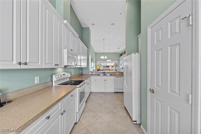 kitchen with white cabinetry, sink, hanging light fixtures, an inviting chandelier, and white appliances