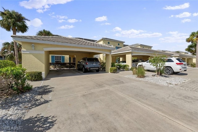 view of parking with driveway and a carport
