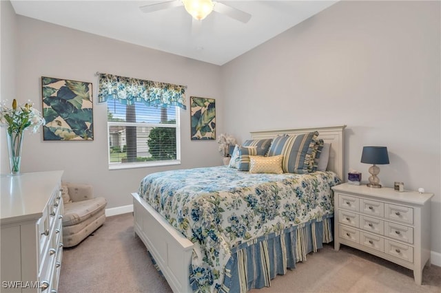 bedroom with light carpet, ceiling fan, and baseboards