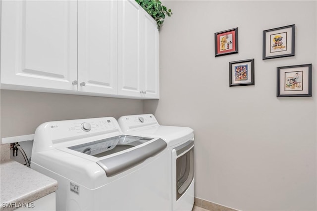 laundry room with cabinet space, washer and clothes dryer, and baseboards