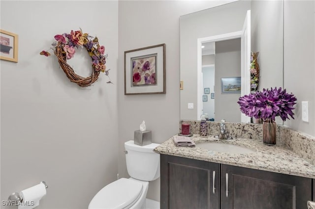 half bathroom with toilet and vanity