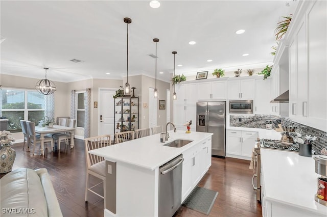 kitchen with dark wood-style floors, light countertops, appliances with stainless steel finishes, a sink, and under cabinet range hood