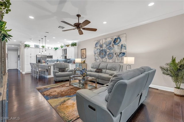 living room with ceiling fan, dark wood-type flooring, and ornamental molding