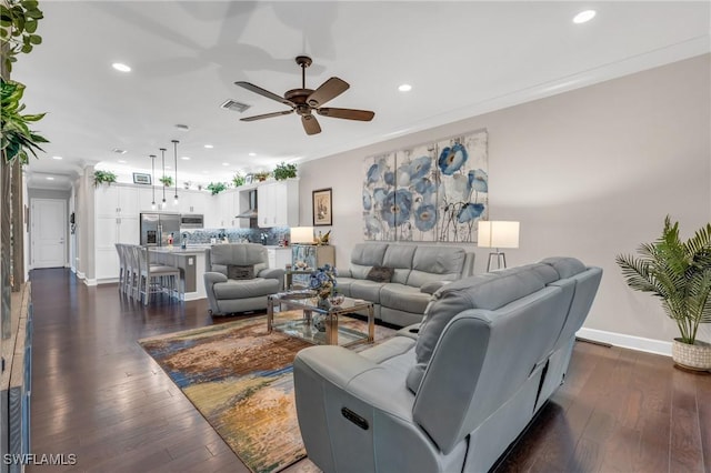 living area featuring dark wood finished floors, crown molding, recessed lighting, visible vents, and baseboards