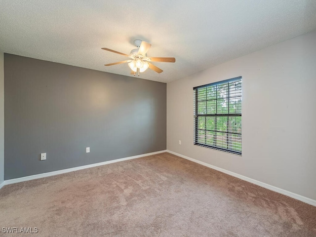 carpeted spare room with ceiling fan and a textured ceiling