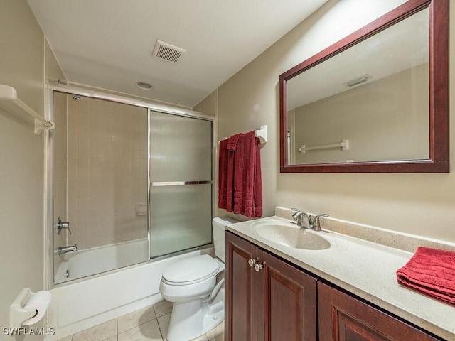 full bathroom featuring tile patterned flooring, vanity, toilet, and bath / shower combo with glass door