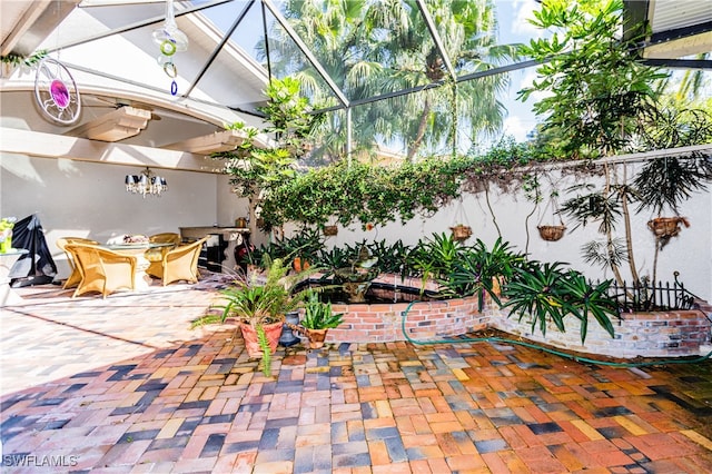 view of patio featuring glass enclosure