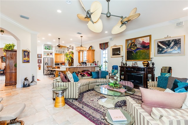 tiled living room featuring ceiling fan and ornamental molding