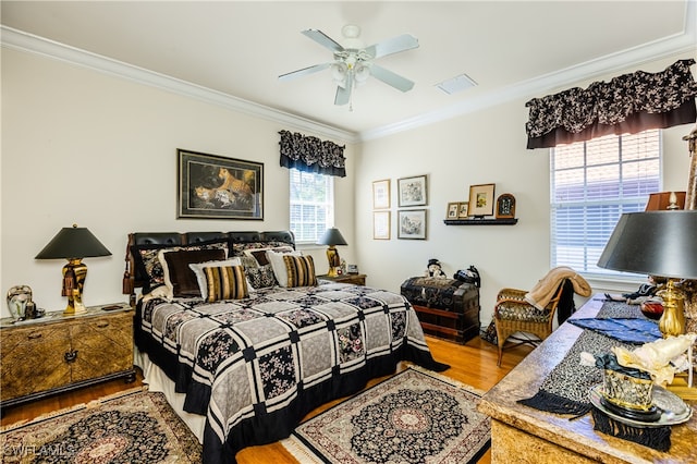 bedroom with wood-type flooring, ceiling fan, and ornamental molding