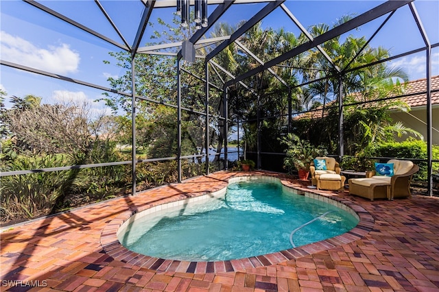 view of swimming pool featuring glass enclosure and a patio area