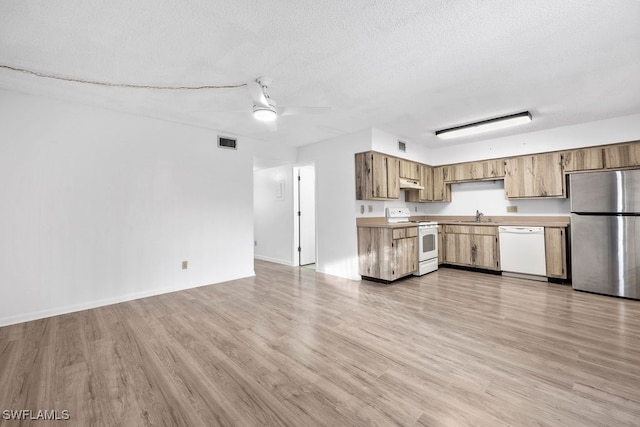 kitchen featuring ceiling fan, sink, a textured ceiling, white appliances, and light wood-type flooring