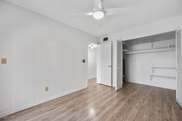 unfurnished bedroom with a closet, ceiling fan, light hardwood / wood-style flooring, and a textured ceiling