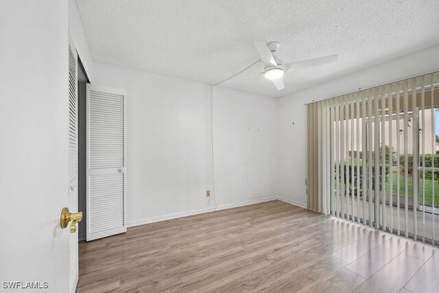 unfurnished room with a textured ceiling, light hardwood / wood-style floors, and ceiling fan