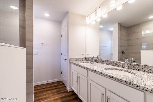 bathroom featuring vanity, hardwood / wood-style flooring, and tiled shower