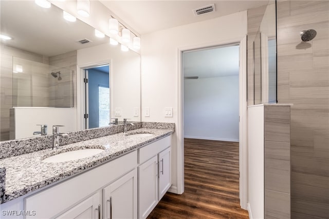 bathroom with vanity, wood-type flooring, and tiled shower