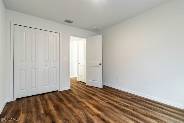 unfurnished bedroom featuring dark wood-type flooring and a closet