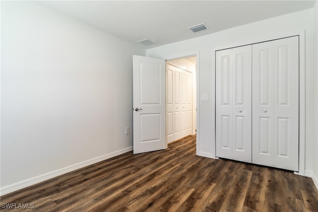 unfurnished bedroom with a closet and dark hardwood / wood-style floors